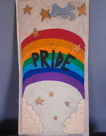 Pancarte utilisée pendant la Pride de Saint-Pierre, on y voit un arc en ciel, au-dessus des nuages, autout, des étoiles.