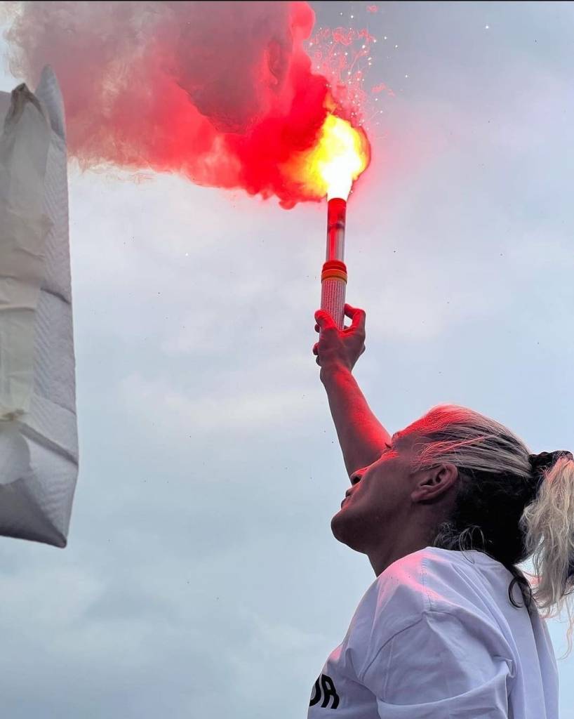 La mère de Naël tenant une fusée de détresse lors de la marche blanche.